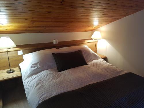 a bedroom with a large bed with two lamps at Luxury Apartment MONTCHAVIN in Montchavin