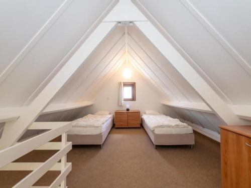 a attic bedroom with two beds and a ladder at Nieuwendamme H114 in Lombardsijde