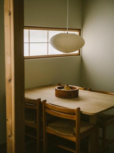a dining room table with chairs and a pendant light at YALDA apartment in Kanazawa