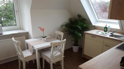 a kitchen with a table and chairs and a sink at Hotel Dorfkrug Büsum in Büsum