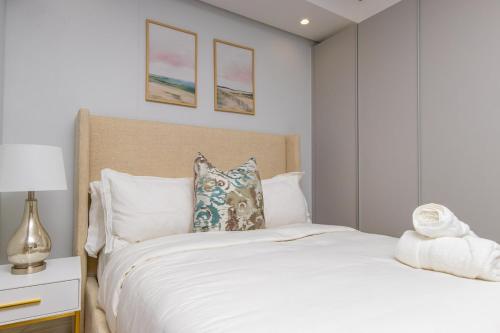 a bedroom with a large white bed and a lamp at The Solace in Midrand