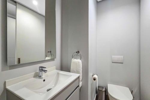 a white bathroom with a sink and a toilet at The Solace in Midrand