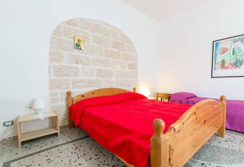 1 dormitorio con cama de madera y pared de piedra en Villino Claudia, en Porto Cesareo