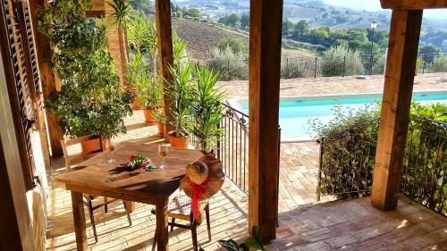 a porch with a table and a view of a pool at Agriturismo Pascucci in Tolentino