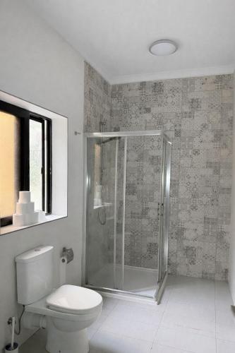 a bathroom with a toilet and a glass shower at Room in sliema's heart in Il-Gżira