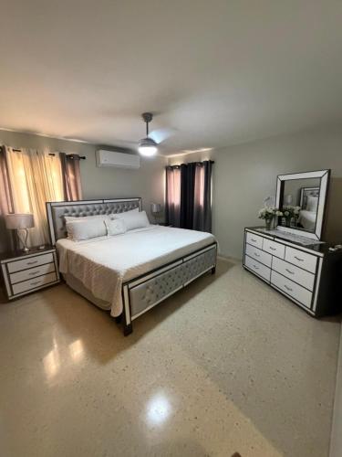 a bedroom with a bed and two dressers and a mirror at madrigal 1-3br with parking in Santiago de los Caballeros