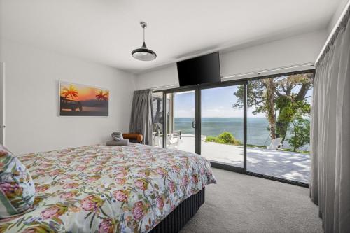 a bedroom with a bed and a view of the ocean at Cliff Top Retreat in San Remo