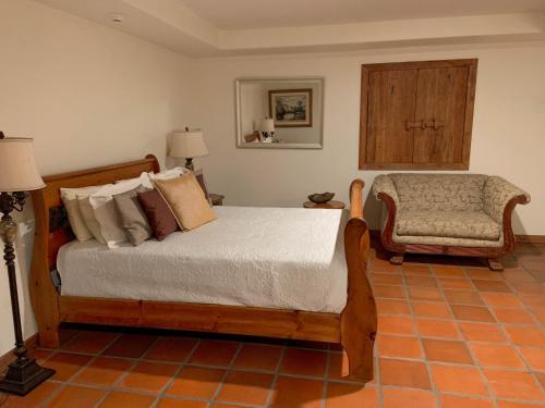a bedroom with a bed and a chair at Hotel Hacienda Santana in Tecate