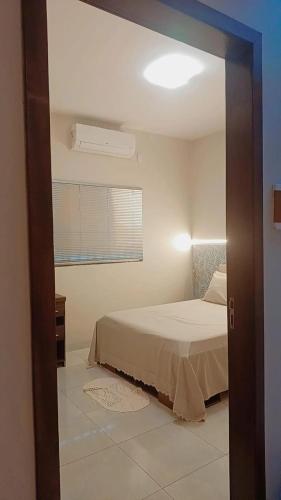 a bedroom with a bed and a window at Casa confortável com garagem coberta in Primavera do Leste
