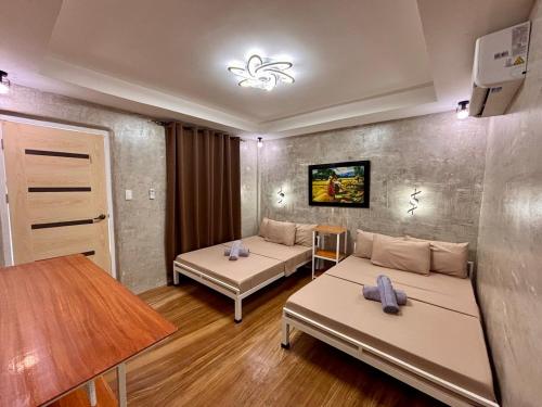 a living room with two beds and a table at Nipa Hut Lodging House in Coron