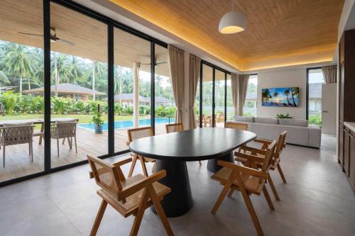 a living room with a table and chairs and a couch at AVA Aurora Villa in Wok Tum