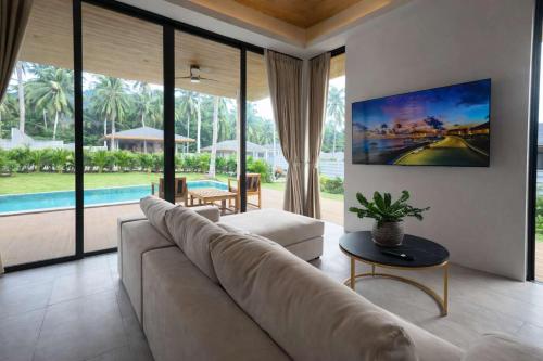 a living room with a large couch and a pool at AVA Aurora Villa in Wok Tum