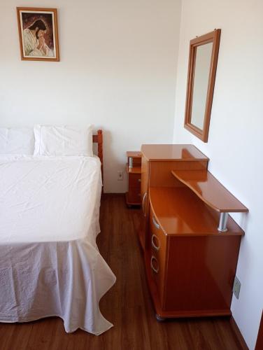 a bedroom with a bed and a dresser with a mirror at Posada domiciliar DB in São Gabriel