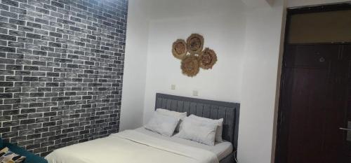a bedroom with a bed and a brick wall at Mardley Suites in Nairobi
