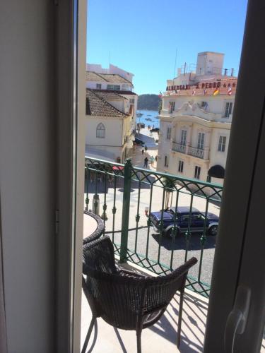 a balcony with a chair and a view of a city at Apartamento Praia São Martinho do Porto in São Martinho do Porto