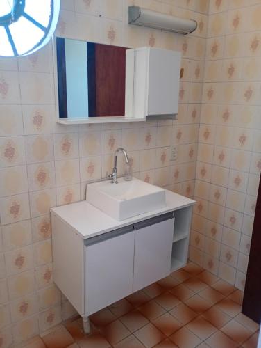 a bathroom with a white sink and a mirror at Posada domiciliar DB in São Gabriel