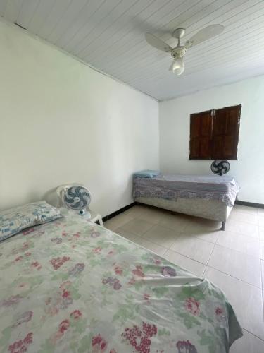 a bedroom with a bed and a ceiling fan at Casa ao ar livre in Aracaju