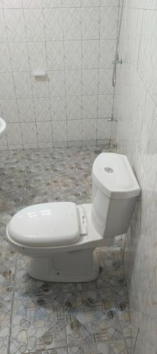 a bathroom with a toilet in a tiled room at Tonton Love in Palimé