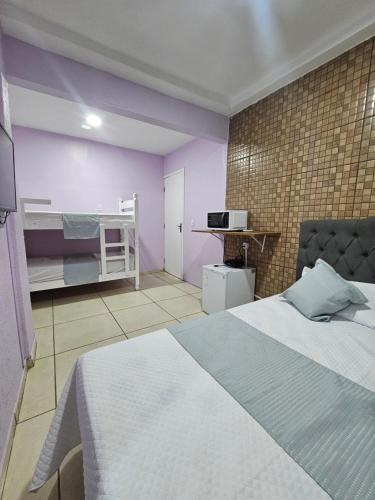 a bedroom with a bed and a bunk bed at Alice Suites in Arraial do Cabo