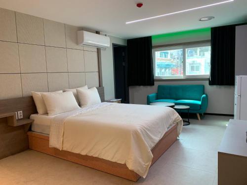 a hotel room with a bed and a blue chair at Hotel Kaya Puerto Galera in Sabang