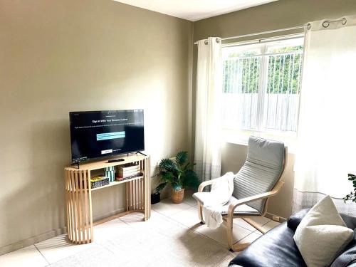 a living room with a flat screen tv on a stand at u5-Traditional QLD unit with backyard-Fresh-Quiet Leafy Centre-NewAC SmartTV in Brisbane