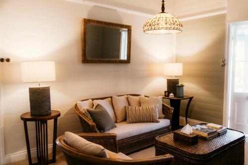 a living room with a couch and chairs and a mirror at Glenelg Upstairs Residence in Murwillumbah