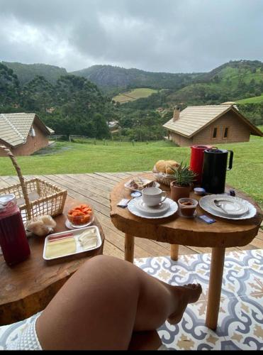 a picnic table with food on it with a view at Pousada das Castanheiras in Monte Verde