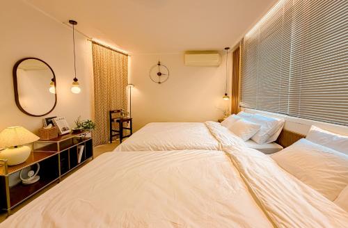 a bedroom with two beds and a window with blinds at Sinnonhyeon Station 5minutes, Gangnam Plastic Surgery, Severance Hospital, COEX, airport bus 5minutes, Hongdae 30minutes, Itaewon 15minutes, 명동 30minutes in Seoul