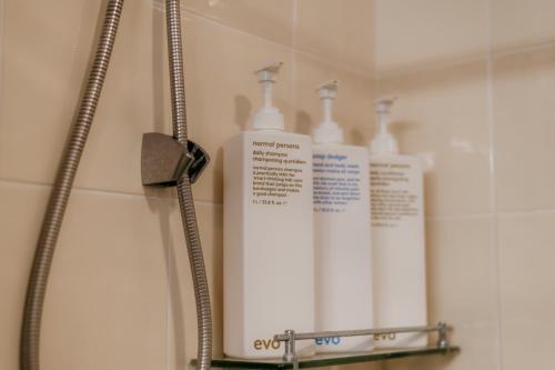 two white bottles ofodorizers on a shelf in a bathroom at Glenelg Downstairs Apartment in Murwillumbah