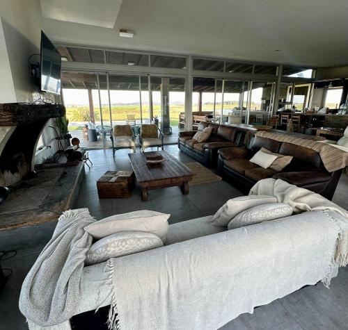 a living room with a large couch with pillows on it at Chacra para 13! A 20min Punta del Este - Starlink in Maldonado