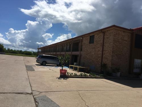 a car parked in a parking lot next to a building at Chaparral Motel in Port Lavaca