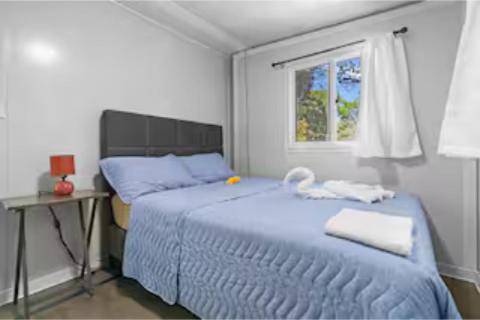 a bedroom with a blue bed and a window at Monkey Houses in Matapalo