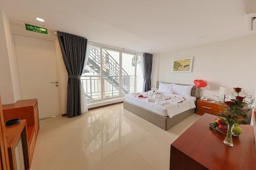 a bedroom with a bed and a table and a window at Sea Light Hotel Nha Trang Beach in Nha Trang