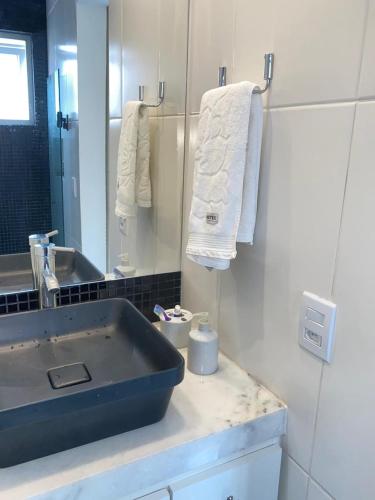 a bathroom with a sink and a mirror and towels at MATER Vila Borges in Rio de Janeiro
