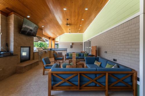 a living room with blue couches and a tv at Bliss Living with Pool, Gym & BBQ I Lndry in Houston