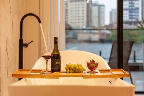 a table with a bottle of wine and a plate of fruit at Azurine Pousada in Passo de Torres