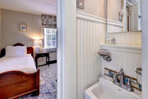 a bedroom with a bed and a tub and a sink at Cedars of Williamsburg Bed & Breakfast in Williamsburg