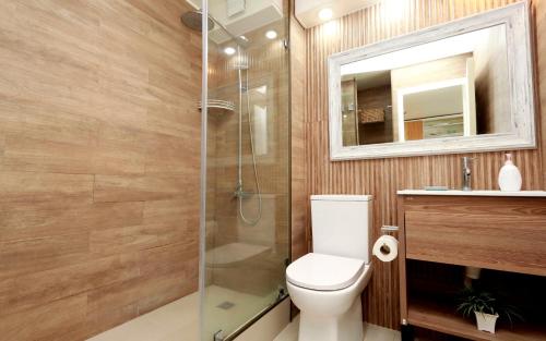 a bathroom with a toilet and a glass shower at Playa Paraíso Resort in Concón