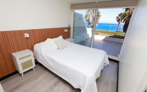 a bedroom with a bed and a view of the ocean at Playa Paraíso Resort in Concón