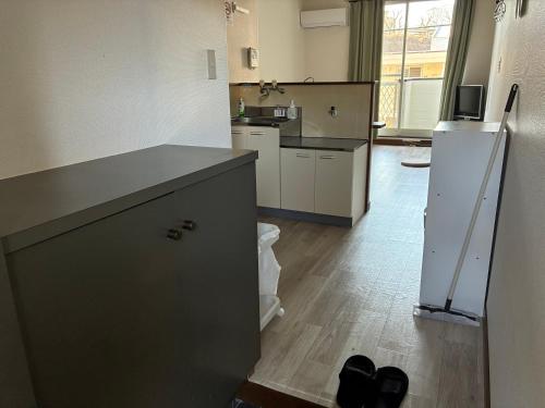 a kitchen with a counter and a refrigerator at アルピエe207号室 軽自動車のみ敷地内無料駐車場Wi-Fi付き in Kumamoto