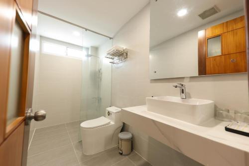 a white bathroom with a toilet and a sink at Sea Light Hotel Nha Trang Beach in Nha Trang