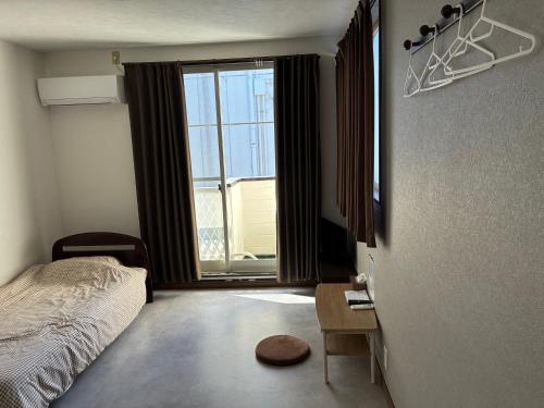 a bedroom with a bed and a large window at アルピエd 201号室 軽自動車無料駐車場Wi-Fiあります お部屋リフォーム済み in Kumamoto