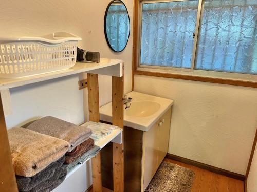 a small bathroom with a sink and a mirror at Cruise garden in Kanō