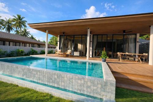 a swimming pool in front of a house at AVA Radharani Villa in Wok Tum