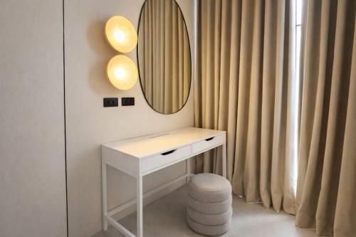 a white dressing table with a mirror and a stool at AVA Radharani Villa in Wok Tum