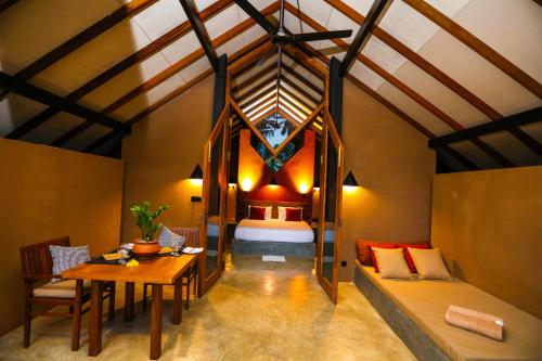 a room with a bed and a table and a bedroom at Nisala Villas in Hikkaduwa