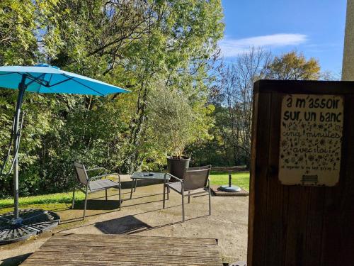a couple of chairs and an umbrella on a patio at Studio indépendant de 2 à 4 personnes in La Biolle