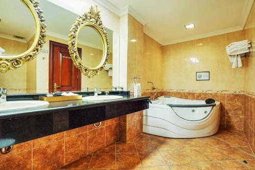 a bathroom with two sinks and a tub and a large mirror at ABC Entertainment Resort in Angeles