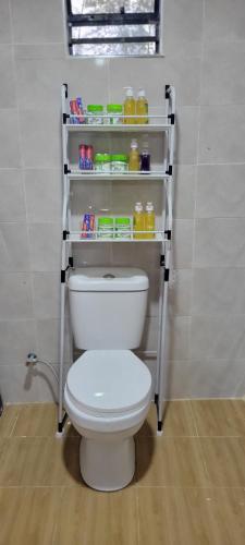 a bathroom with a toilet with shelves on the wall at Destiny Paradise in Amagoro