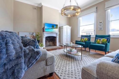 a living room with two couches and a fireplace at Fox House Scone - Apartments in Scone